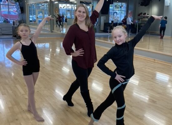 Two young girls and an instructor holding a dance pose
